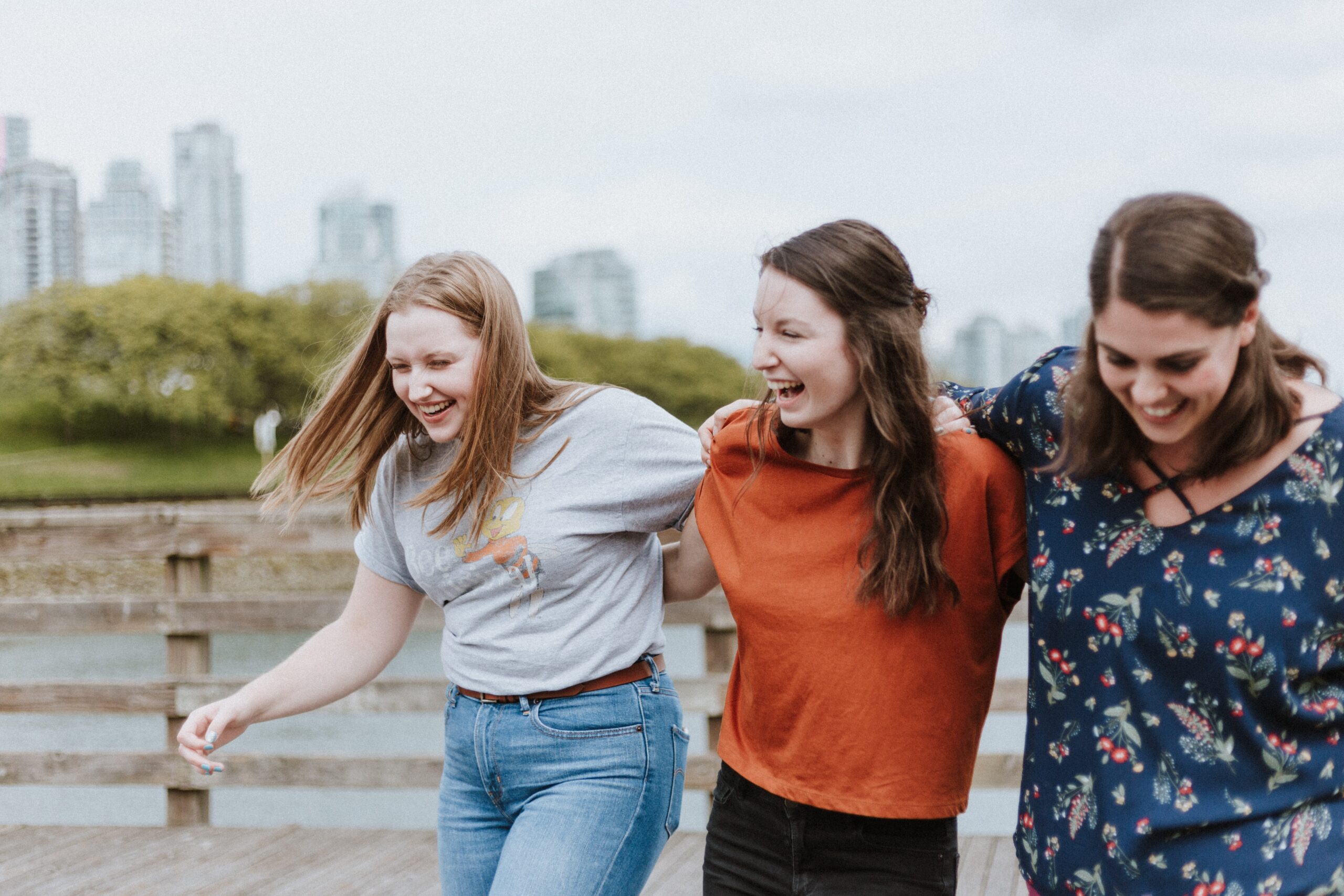 Three people linking arms and laughing