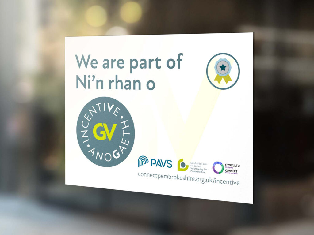 A window sign which is white with the Volunteering for Pembrokeshire branding on it