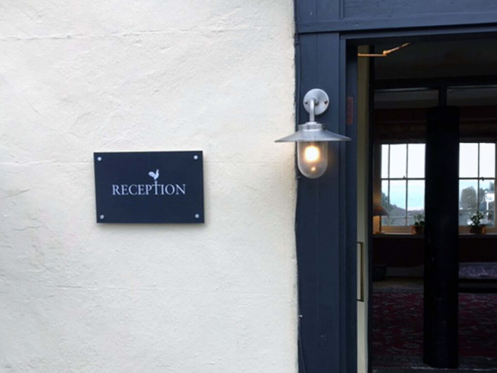 A white wall with a blue door and a blue sign