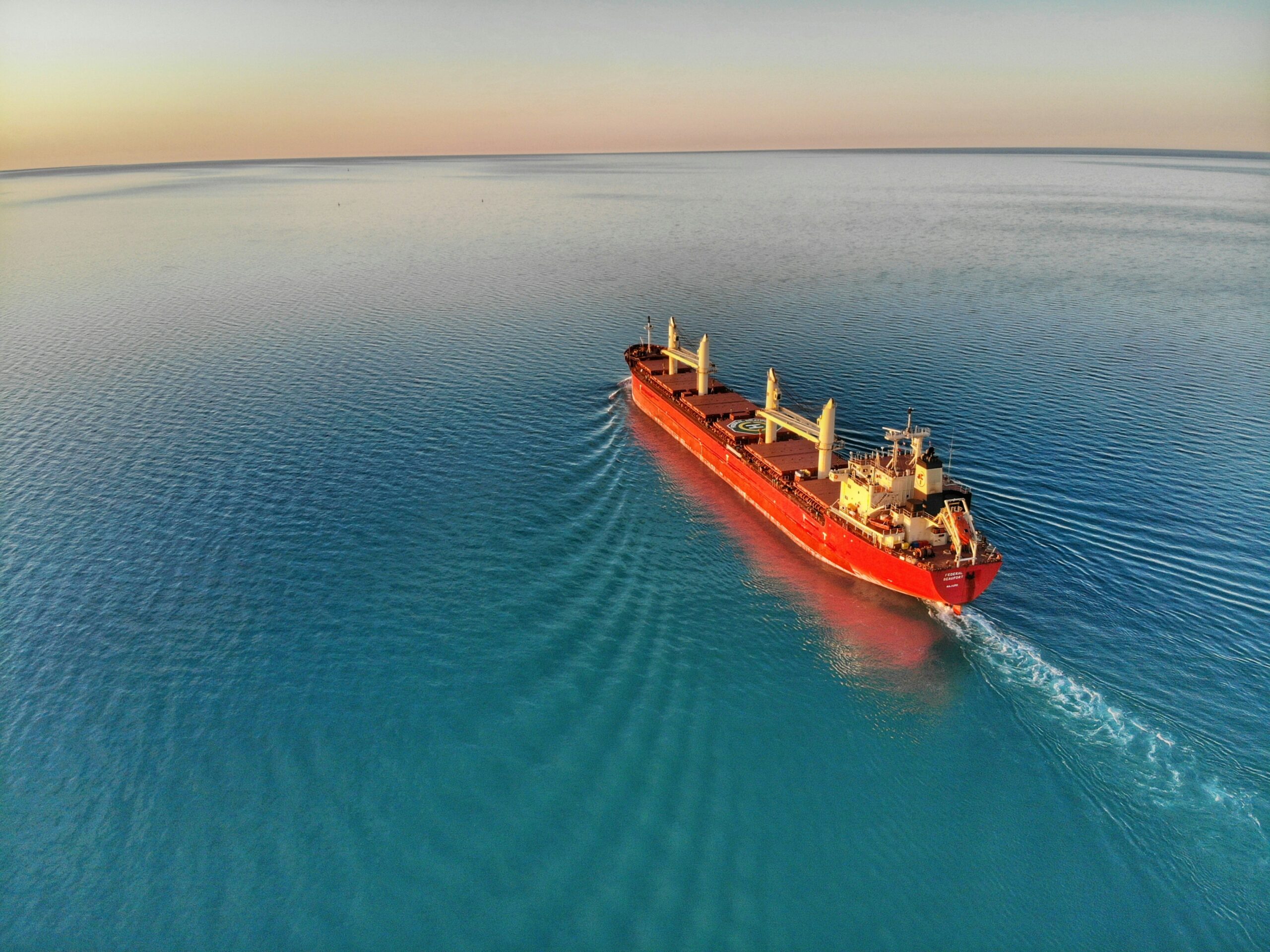 A wide view of the sea with a red shipping container