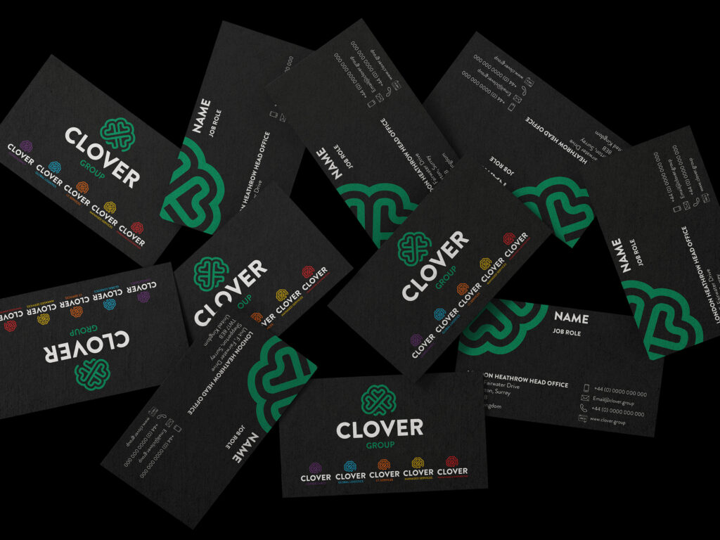 A range of black business cards with the Clover Group logo on a black background