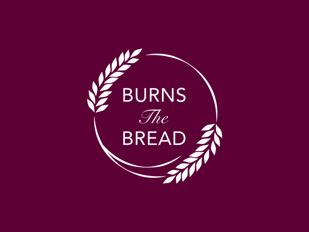 A purple background with a white logo made up of two wheat stems forming a circle with 'Burns the Bread' written inside
