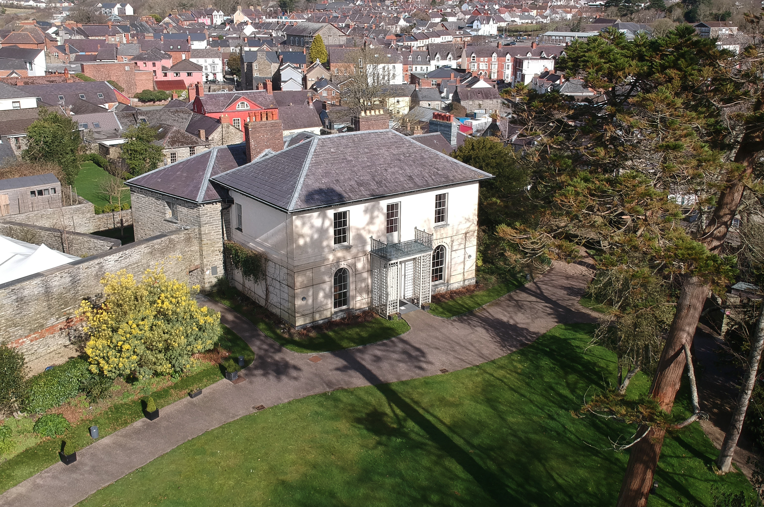 A drone shot of a large manor house on the grounds of Cardigan Castle