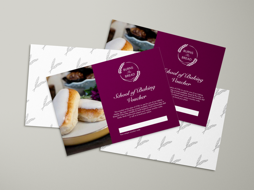 Four postcard sized vouchers, two of which feature a repeating wheat print and the other two featuring an image of iced buns